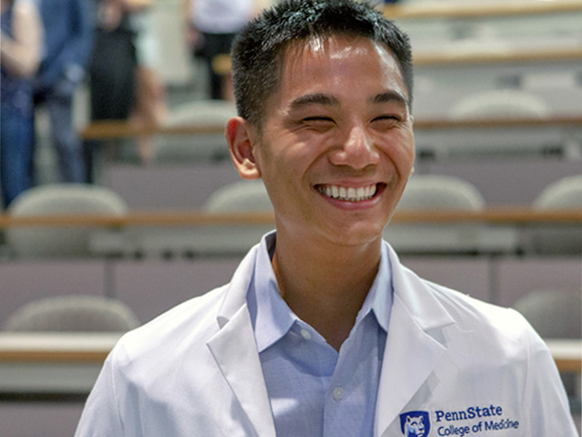 穿着白色实验服的微笑医学院学生。
